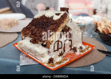 Biskuitkuchen mit Schokolade und Schlagsahne in Form eines Hauses, weicher Fokus Stockfoto