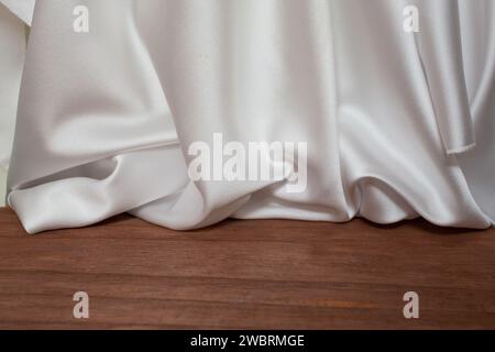 Leerer Holzboden mit eleganten gewellten weißen Satin-Stoffvorhängen, Unschärfe im Hintergrund, Produktplatzierung Stockfoto