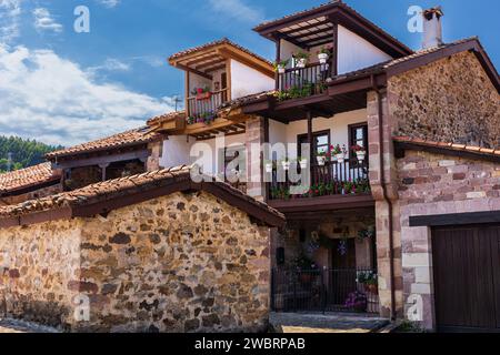 Traditionelle alte, ländliche Berghütten aus Stein mit Balkonen und Blumen. Carmona, Kantabrien, Spanien. Stockfoto
