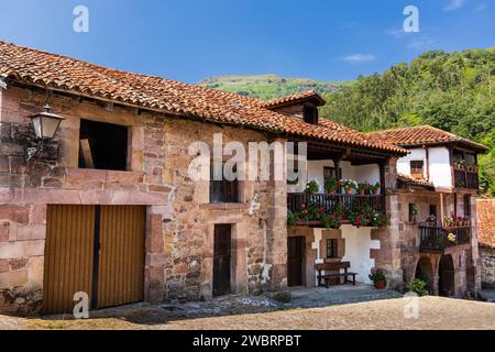 Straße der kleinen Stadt Carmona, traditionelle alte Landhäuser aus Stein mit Balkonen und Blumen. Carmona, Kantabrien, Spanien. Stockfoto