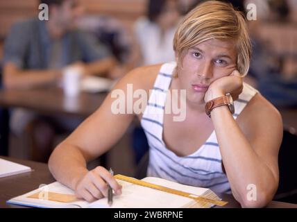 Universität, gelangweilt und Porträt des Mannes im Klassenzimmer mit Büchern zum Studium, Lernen und Forschung. Bildung, College und Gesicht des Studenten müde, traurig Stockfoto