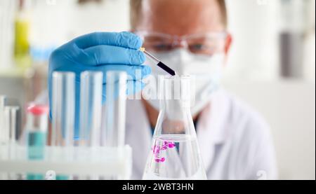 Eine männliche Chemiker hält Reagenzglas aus Glas Stockfoto