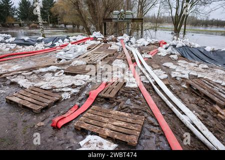 Sachsen-Anhalt, Oberröblingen: 12. Januar 2024, nachdem das Helme-Hochwasser zurückgegangen ist, liegen THW-Schläuche hinter einem provisorischen Deich. Da sich die Lage am Damm und entlang der Helme entspannt, plant der Landkreis Mansfeld-Südharz, den Ausnahmezustand aufzuheben. Kurz vor Ende des Jahres brach die Helme an Stellen im Landkreis im Süden Sachsen-Anhalts über die Ufer. Nachdem der Landkreis am 30. Dezember den Katastrophenzustand ausgerufen und damit die Organisation übernommen hatte, wurden ab dem 5. Januar rund 200 Soldaten nach Sachsen-Anhalt eingesetzt. Foto: Jan Woitas/dpa Stockfoto