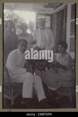 Die Firma umfasst Mitglieder der Familie Terlaak auf einer Veranda während einer Bamellsaison, möglicherweise in Suriname, ca. 1920 - ca. 1930 Foto Teil eines Fotoalbums einer unbekannten niederländischen Familie mit Aufnahmen von Suriname, Europa und den Niederländisch-Indien. Suriname (möglicherweise) fotografische Unterstützung erwachsener Frauen. Erwachsener Mann. Hausvögel (im Haus) Suriname Stockfoto