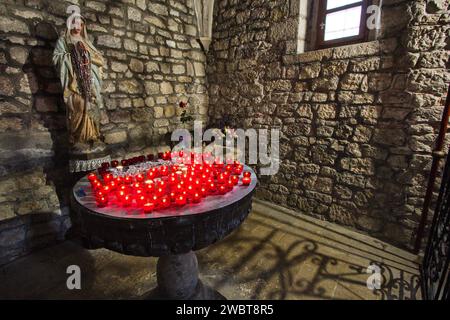 Die Kirche des Heiligen Franziskus und ihr Kloster in Krk Stadt, Insel Krk Kroatien - das Innere der Kapelle. Kerzen mit der Marienstatue. Stockfoto