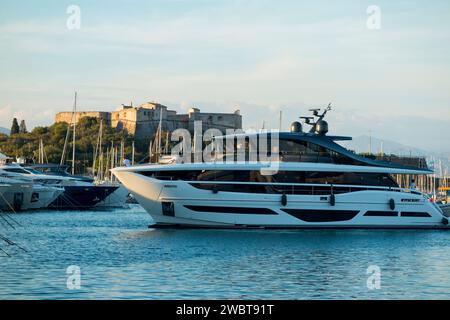 Luxus-Superyachten, die im Hafen von Port Vauban, Antibes, vertäut sind. Ein Boot manövriert im Hafen, mit Blick auf das sternförmige Fort Carré. Frankreich. (135) Stockfoto