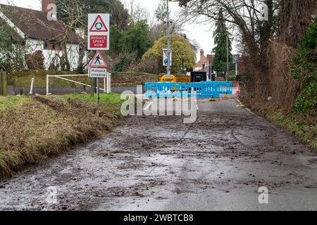 Cookham, Großbritannien. Januar 2024. Rückstände von Hochwasser, die nach dem Hochwasser auf der Straße hinterlassen wurden. Die B4447-Hauptstraße durch Cookham Moor im Dorf Cookham, Berkshire, bleibt wegen Überschwemmungen durch die Themse gesperrt. Die alte Straße daneben, genannt Causeway, ist für bestimmte Stunden geöffnet, damit eine begrenzte Anzahl von Fahrzeugen die Brücke überqueren kann. Quelle: Maureen McLean/Alamy Live News Stockfoto