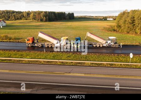 Drohnenfotografie von Autobahnreparaturen mit schweren Industriemaschinen am sonnigen Herbstmorgen Stockfoto