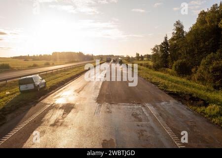 Drohnenfotografie von Autobahnreparaturen mit schweren Industriemaschinen am sonnigen Herbstmorgen Stockfoto