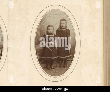 Porträt zweier Mädchen mit einem Sprungseil, J. Meyer and Co, 1885 - 1910 Foto. Visitenkarte dieses Foto ist Teil eines Albums. Meppel-Karton. Fotografische Unterstützung historischer Personen - BB - Frau. Mädchen (Kind zwischen Kleinkind und Jugend) (+ zwei Personen). Seilspringen Stockfoto