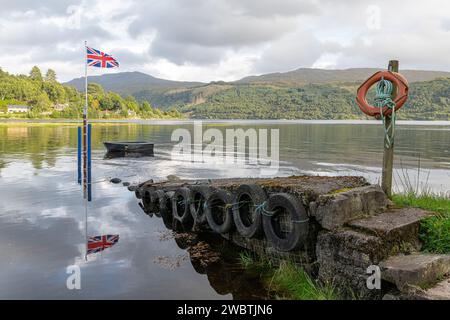 Die Flagge der Union Jack an einem Stange mit einem Boot, das bei Flut im See Loch Sunart in Strontian, Highlands, Schottland gefesselt ist Stockfoto