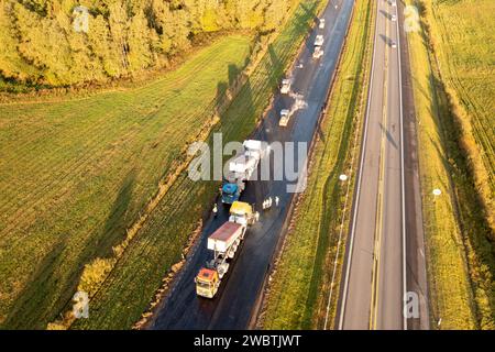 Drohnenfotografie von Autobahnreparaturen mit schweren Industriemaschinen am sonnigen Herbstmorgen Stockfoto