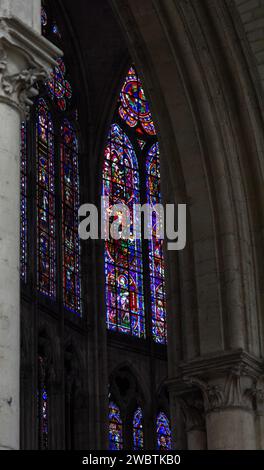 Farbenprächtige Buntglasfenster aus dem XIII. Jahrhundert im Kirchenschiff von St. Paul und St. Peter Kathedrale in Troyes, Frankreich, durch einen Steinbogen gesehen. Stockfoto