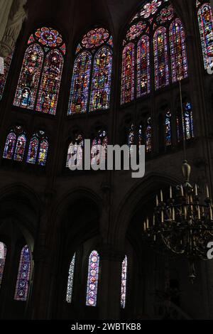 Die Buntglasfenster aus dem XIII. Jahrhundert der Kathedrale St. Paul und St. Peter in Troyes, Frankreich, leuchten hell im dunklen Inneren des gotischen Gebäudes. Stockfoto