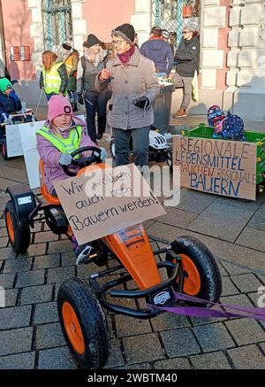 12.01.2024, Bad Wörishofen im Unterallgäu, fünfter Tag beim großen Bauernstreik. Eine Kolonne Kids mit ihren Spielzeug-Traktoren fährt mit Protestplakaten durch die Mindelheimer Innenstadt. Plakat auf dem Kettcar: Wir wollen auch bauer werden regionale Lebensmittel brauchen regionale Bauern 12.01.2024, Kinder beim Bauernstreik 12.01.2024, Kinder beim Bauernstreik *** 12 01 2024, Bad Wörishofen in Unterallgäu, fünfter Tag der großen Bauern schlagen Eine Spalte von Kindern mit ihren Spielzeugtraktoren fährt durch das Zentrum von Mindelheim mit Protestplakaten Poster auf dem Kettcar We Want to be Farmers too R Stockfoto