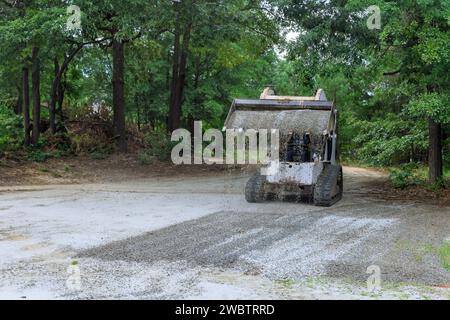 Der Minilader von Bobcat bewegt während der Bauarbeiten den Löffel mit Schotter aus zerdrücktem Stein Stockfoto