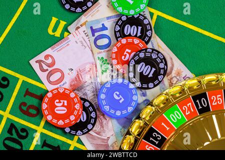 Auf dem grünen Spieltisch gibt es Roulette, georgische Banknoten in Lari Poker Chips. Stockfoto