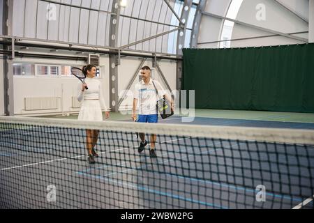 Fröhlicher Mann und Frau, nachdem sie Tennis gespielt haben Stockfoto