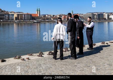 BUDAPEST, UNGARN – 16. MÄRZ 2023: Dies sind nicht identifizierte Vertreter der jüdischen Religionsgemeinschaft bei den Schuhen am Holocaust-Embankment Stockfoto