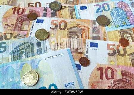 Nahaufnahme eines Stapels Euro-Banknoten und -Münzen. Stockfoto