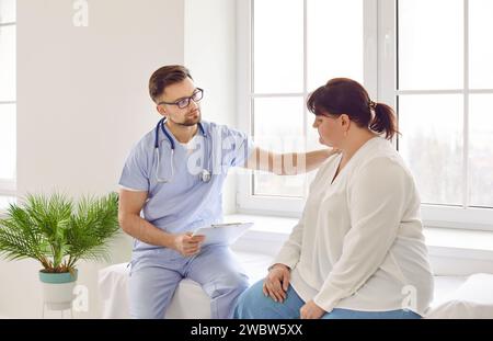 Doktor unterstützt traurige, fette Frau, hält die Hand auf der Schulter und drückt Mitgefühl aus Stockfoto