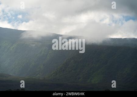 Schichten von Nebel und Sonnenlicht bedecken die grünen Bergrücken von Maui und schaffen eine ätherische bergkulisse, die fasziniert und inspiriert. Stockfoto