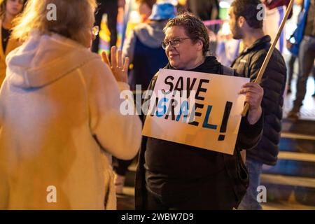 Haifa, Israel - 21. Januar 2023: Die Menschen protestieren mit Zeichen gegen die Legislativpläne der neuen Regierung. Eine Frau hält ein Banner, auf dem "Save" steht Stockfoto