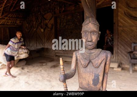 Traditionelles, aus Holz geschnitztes Statut, das von Mitgliedern des Konyak-Stammes am Eingang zum traditionellen Langhaus im Longwa-Dorf nagaland, indien, hergestellt wurde Stockfoto