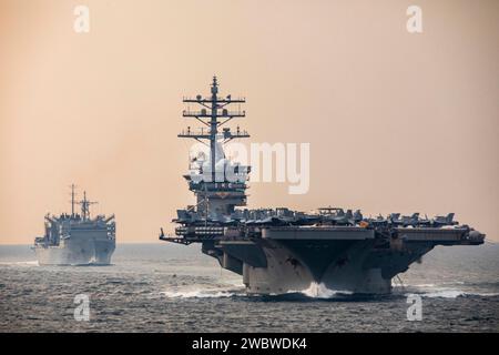 Strait of Hormuz, USA. Dezember 2023. Der US Navy-Flugzeugträger USS Dwight D. Eisenhower führt das schnelle Kampfflugschiff USNS Supply während der Operation Prosperity Guardian am 14. Dezember 2023 im Persischen Golf durch die Straße von Hormuz. Die OPG ist eine multinationale Koalition zur Unterstützung der Sicherheit im Seeverkehr und zur Bekämpfung von Angriffen auf die Handelsschifffahrt in der Region. Kredit: MC2 Keith Nowak/USA Navy Photo/Alamy Live News Stockfoto