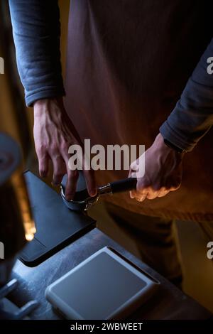 Prozess der Kaffeezubereitung, der frisch gemahlene Kaffeebohnen im Portafilter tönt Stockfoto