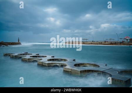 Eine malerische Mauer inmitten der Weite des Ozeans, mit einer bezaubernden Darstellung von Wellen, die gegen sie krachen Stockfoto