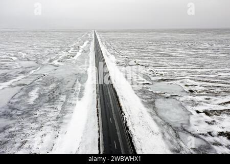 Aus der Vogelperspektive über die leere Route 1 / Ring Road, zweispurige Nationalstraße in einer verschneiten Winterlandschaft, Suðurland / Südregion, Island Stockfoto