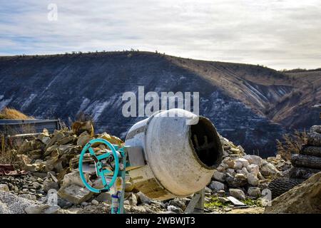 Elektrischer Betonmischer. Baustelle im Hintergrund des Berges. Nahaufnahme. Selektiver Fokus. Kopierbereich Stockfoto