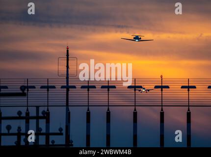 Start- und Landebahnbeleuchtung, Anflughilfen, am Flughafen Düsseldorf, Sonnenuntergang, Flugzeuge, die auf die südliche Hauptbahn starten und sich nähern, 05R/23L, NR Stockfoto