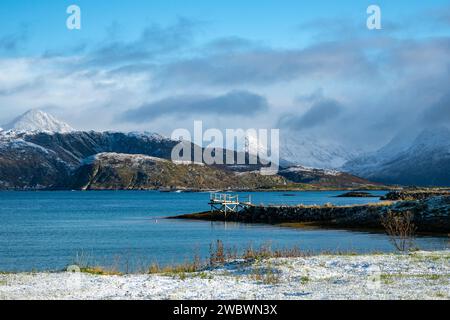 Bootssteg, Anlegestelle, Bootssteg mit farbigen Häusern am Ufer des Nordatlantiks. Bootshaus und hölzernes Ferienhaus auf den Inseln von Kvaløya, Norwegen Stockfoto