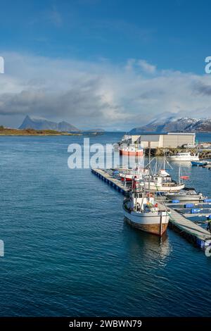 Bootssteg, Anlegestelle, Bootssteg mit farbigen Häusern am Ufer des Nordatlantiks. Bootshaus und hölzernes Ferienhaus auf den Inseln von Kvaløya, Norwegen Stockfoto