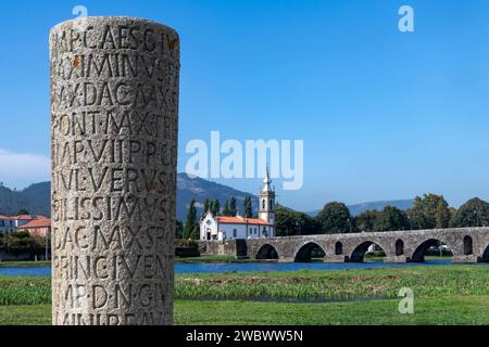 Ponte de Lima, Portugal, 7. Oktober 2023; Steinsäule mit römischen Buchstaben und Ponte Romano-Gótica de Ponte de Lima über dem Fluss Lima Stockfoto