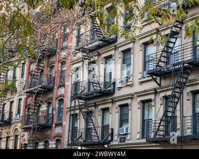 Alte farbenfrohe Gebäude mit Feuerleiter und Bäumen in New york manhattan, Upper East Side, Gebäude-Fronthaus Stockfoto