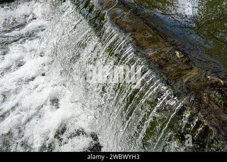 Wasserkaskadierung über Wehr mit weißem Schaumwasser Stockfoto