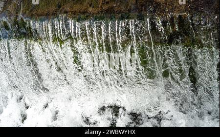 Wasserkaskadierung über Wehr mit weißem Schaumwasser Stockfoto