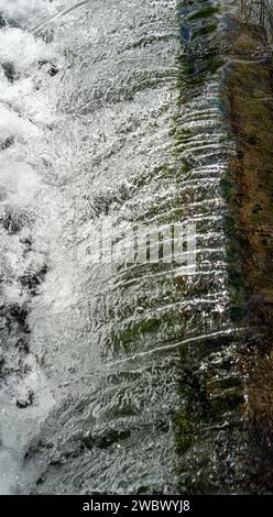Wasserkaskadierung über Wehr mit weißem Schaumwasser Stockfoto