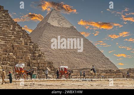 Gizeh Necropolis, Ägypten - 26. April 2022: Beduinen in traditionellen Kleidern und Touristen, vor dem Pyramidenkomplex von Gizeh Necropolis. Stockfoto