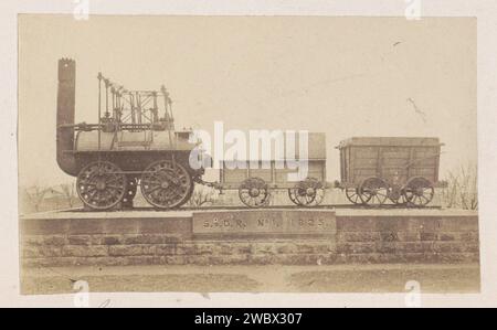 Lokomotive mit Anhängern auf einem Sockel, anonym, 1878 - 1890 Foto auf einem Ziegelfuß ist eine Dampflokomotive mit einem Tender für Wasser und Kraftstoff und einem Wagen. Darunter war der Text geschnitzt: 'S. & D.R. No. 1. 1825. ". Dies bezieht sich auf die Locomotion No. 1., die erste Lokomotive, die auf der Strecke der Stockton and Darlington Railway (S. & D.R.) fuhr und von George Stephenson (1781–1848) gebaut wurde. Teil des Reisealbums European Cities, vermutlich Schwedisch. Darlington fotografische Trägeralbumendruck-Dampflokomotive. Denkmal, Statue Darlington Stockfoto