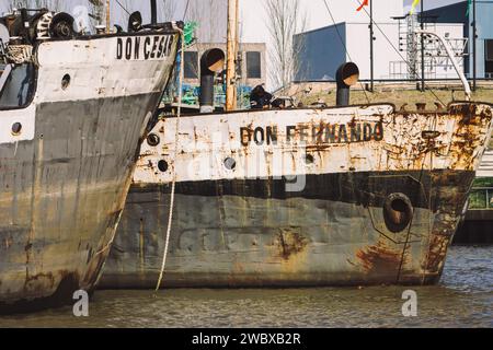 Zwei alte, verrostete Schiffe legten an einem Flusshafen in Tigre (Argentinien) an Stockfoto