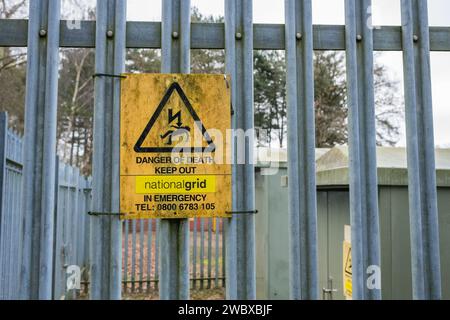 Gefahr, Elektrizität, Stromschlaggefahr, Warnhinweis an einem verzinkten Metallzaun angebracht. Stockfoto