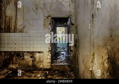 Das Innere eines baufälligen Hauses mit viel Schmutz und Schutt an Wänden und Böden. Stockfoto