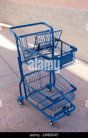 Kleiner blauer Einkaufswagen außerhalb eines Marktes. Hoher Blickwinkel. Stockfoto