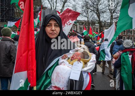 Den Haag, Südholland, Niederlande. Januar 2024. Ein pro-palästinensischer Demonstrant hält ein künstliches Baby, das mit Blut bedeckt ist. Am 12. Januar 2024 demonstrierten pro-israelische und pro-palästinensische Aktivisten vor dem Internationalen Gerichtshof in den Haag. Innerhalb des Gerichtshofs verteidigte sich Israel gegen Südafrikas Anklage des Völkermordes. (Kreditbild: © James Petermeier/ZUMA Press Wire) NUR REDAKTIONELLE VERWENDUNG! Nicht für kommerzielle ZWECKE! Stockfoto