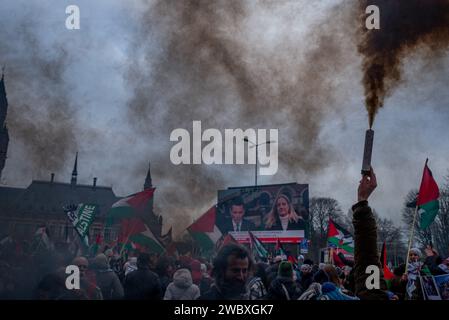 Den Haag, Südholland, Niederlande. Januar 2024. Ein pro-palästinensischer Demonstrant zündet eine Rauchbombe an. Am 12. Januar 2024 demonstrierten pro-israelische und pro-palästinensische Aktivisten vor dem Internationalen Gerichtshof in den Haag. Innerhalb des Gerichtshofs verteidigte sich Israel gegen Südafrikas Anklage des Völkermordes. (Kreditbild: © James Petermeier/ZUMA Press Wire) NUR REDAKTIONELLE VERWENDUNG! Nicht für kommerzielle ZWECKE! Stockfoto