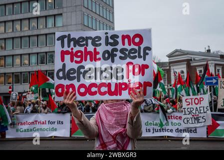 Den Haag, Südholland, Niederlande. Januar 2024. Ein pro-palästinensischer Demonstrant trägt ein Protestzeichen. Am 12. Januar 2024 demonstrierten pro-israelische und pro-palästinensische Aktivisten vor dem Internationalen Gerichtshof in den Haag. Innerhalb des Gerichtshofs verteidigte sich Israel gegen Südafrikas Anklage des Völkermordes. (Kreditbild: © James Petermeier/ZUMA Press Wire) NUR REDAKTIONELLE VERWENDUNG! Nicht für kommerzielle ZWECKE! Stockfoto